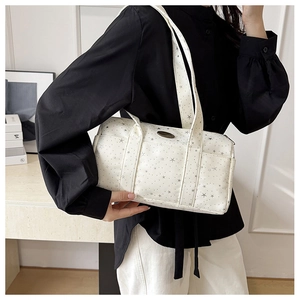 White cylinder shoulder bag with star prints and metal plate detail on a model