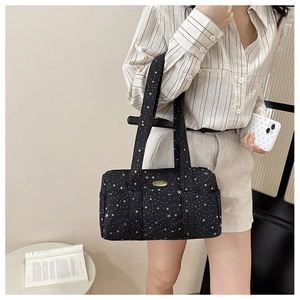 Detail of black star print canvas shoulder bag with gold logo and side pocket