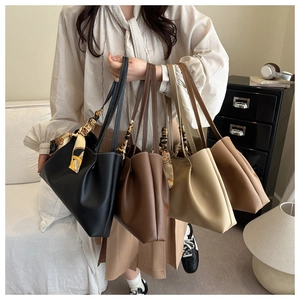 Detail view of four large tote bags with silk scarves on handles in a lifestyle setting