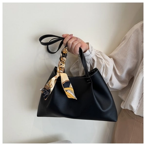 Detail of black tote bag with decorative printed silk scarf and adjustable strap