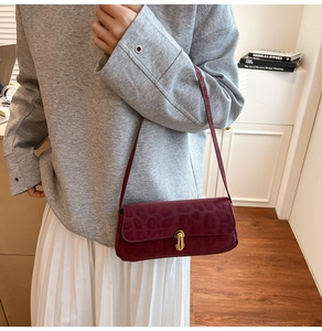 Detail of dark red leopard print shoulder bag featuring a sleek golden cylinder metal lock