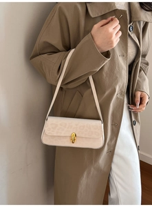 Detail of a chic leopard print shoulder bag with a gold metal twist lock and slim strap