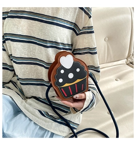 Detail of a cupcake shaped mini crossbody bag featuring white heart and fine stitching