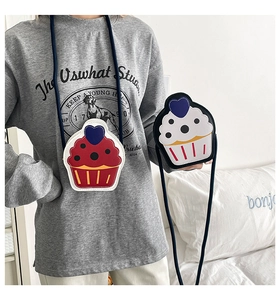 Close-up of cute cupcake-shaped mini crossbody bags with blue heart decor and straps
