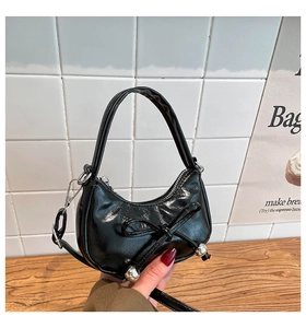 Détail du sac hobo noir avec nœud en perles et finition en cuir brillant poli