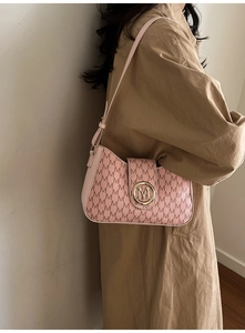 Detail of pink monogram underarm bag with golden M logo buckle and leather strap