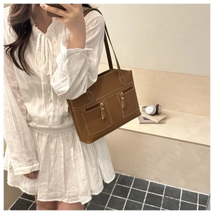 Brown vintage leather tote bag with white stitching detail and dual zipper front pockets