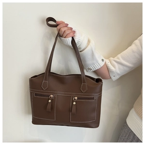 Détail du sac cabas marron foncé avec surpiqûres blanches et poches avant zippées