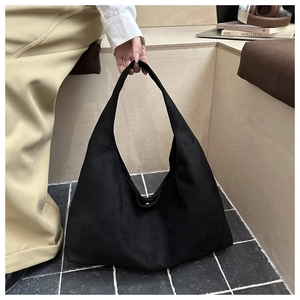 Detail of minimalist black faux suede hobo bag showing large capacity and soft matte texture