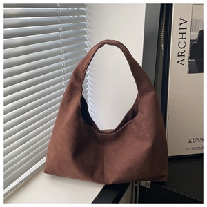 Close-up of vintage dark brown faux suede tote bag with soft matte texture and light detail
