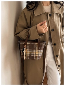 Detailed view of a retro plaid tote bag with beaded tassel and leather strap handles