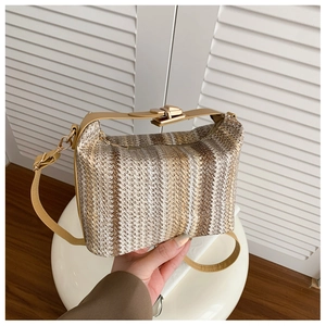 Détail d'un sac en paille rayé avec lanières en cuir synthétique et boucle dorée
