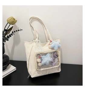 Detail of off-white ita bag canvas tote with clear window and plush star pendant charm