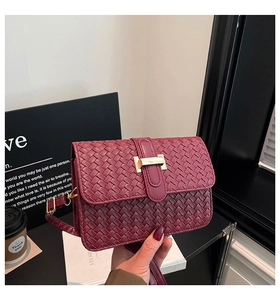 Close-up of wine red woven leather crossbody bag featuring a golden H-shaped buckle