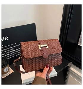 Close-up of dark brown woven leather texture and gold rectangular metal buckle detail
