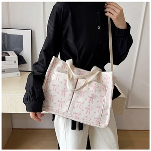 Detail of corduroy tote bag with pink bow prints featuring sturdy shoulder straps