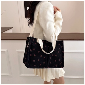 Corduroy tote bag with strawberry print shown on model for daily commuting use