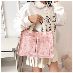 Detail of pink corduroy tote bag with bow patterns and adjustable shoulder strap