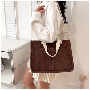 Brown corduroy tote bag with red strawberry pattern shown on model for daily commute