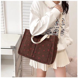 Brown corduroy tote bag with red heart patterns and dual front pockets detail