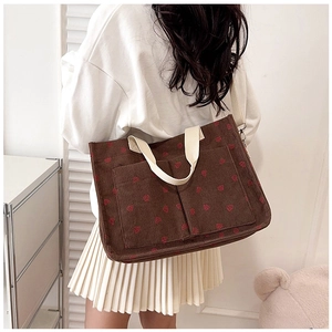 Detail of strawberry print corduroy tote bag showing front pockets and shoulder strap