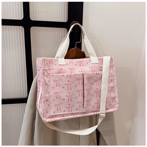 Detailed corduroy texture of pink tote bag with bow heart print and dual front pockets