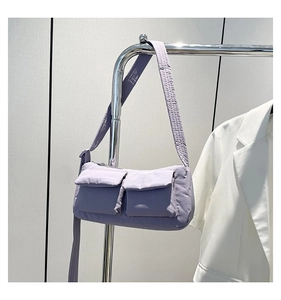 Close-up of a light purple nylon shoulder bag with dual front utility cargo pockets