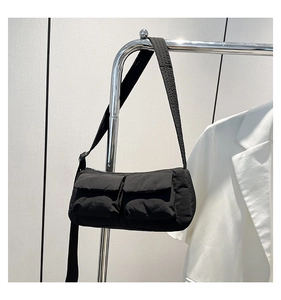 Detail of black puffy nylon shoulder bag with two front pockets on a silver hanger