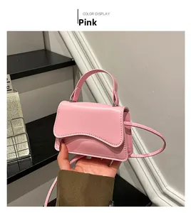 Detailed view of pink crossbody bag featuring scalloped edges and textured faux leather