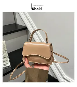 Detail of khaki mini handbag featuring a wave-edge flap and smooth matte faux leather texture