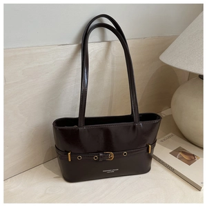 Close-up of vintage dark brown faux leather tote bag with gold buckle detail and logo