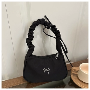 Détail du sac à bandoulière plissé noir avec nœud en métal argenté et forme de croissant