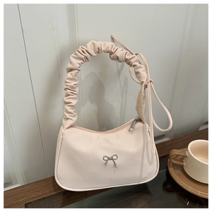 Détail d'un sac demi-lune avec poignée plissée et décoration de nœud en argent élégant