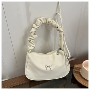 Détail du sac hobo blanc cassé avec poignée plissée et nœud en métal argenté