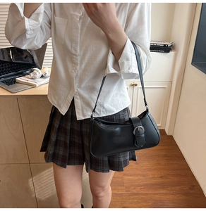 Detailansicht der schwarzen PU-Baguette-Tasche mit Silberschnalle an einem Model