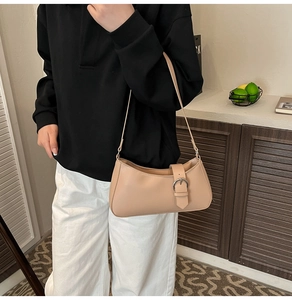 Beige PU leather underarm bag with decorative metal buckle shown in a lifestyle scene