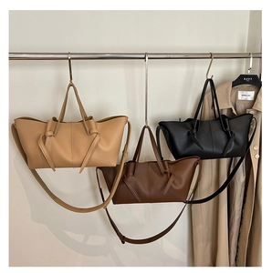 Close-up of pleated leather tote bags in khaki, chocolate, and black with knotted handles