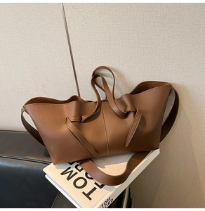 Détail du sac cabas marron caramel avec nœud décoratif et texture en cuir minimaliste