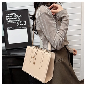 Détails d'un sac cabas minimaliste beige avec surpiqûres et finitions à franges