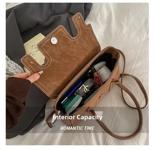 Detailed view of the brown suede bag interior capacity with cosmetic items