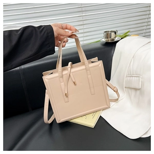 Détails d'un sac à bandoulière beige brillant avec ferrures dorées et cordons de serrage