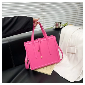 Détail du sac à bandoulière rose fuchsia avec design structuré et cordon à nœud en métal
