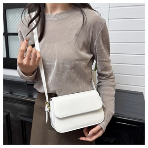 Détail d'un sac bandoulière en similicuir blanc avec des finitions dorées