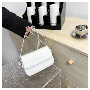Vue détaillée du sac porté épaule en cuir blanc avec boucles et bandoulière fine