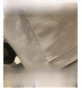 Macro detail of beige canvas tote bag showing thick woven texture and fine stitching