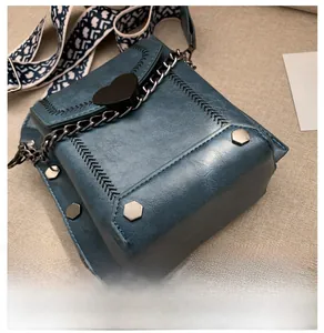 Detailansicht des blauen Kunstleder-Taschenbodens mit gewebtem Gurt und Metallkette