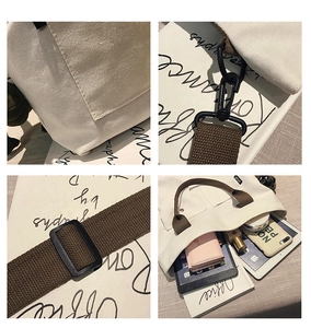 Detail view of large canvas tote bag with brown straps showing inner capacity and metal hooks