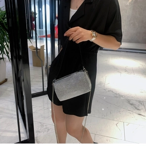 Détail d'un sac à bandoulière en strass argentés avec chaîne et poignée sur un mannequin