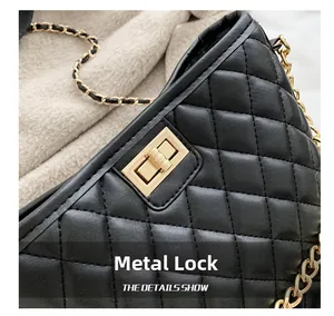 Close-up of golden square metal clasp on black quilted leather crossbody bag