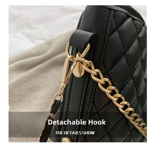 Close-up of a golden detachable hook on a black quilted chain shoulder handbag